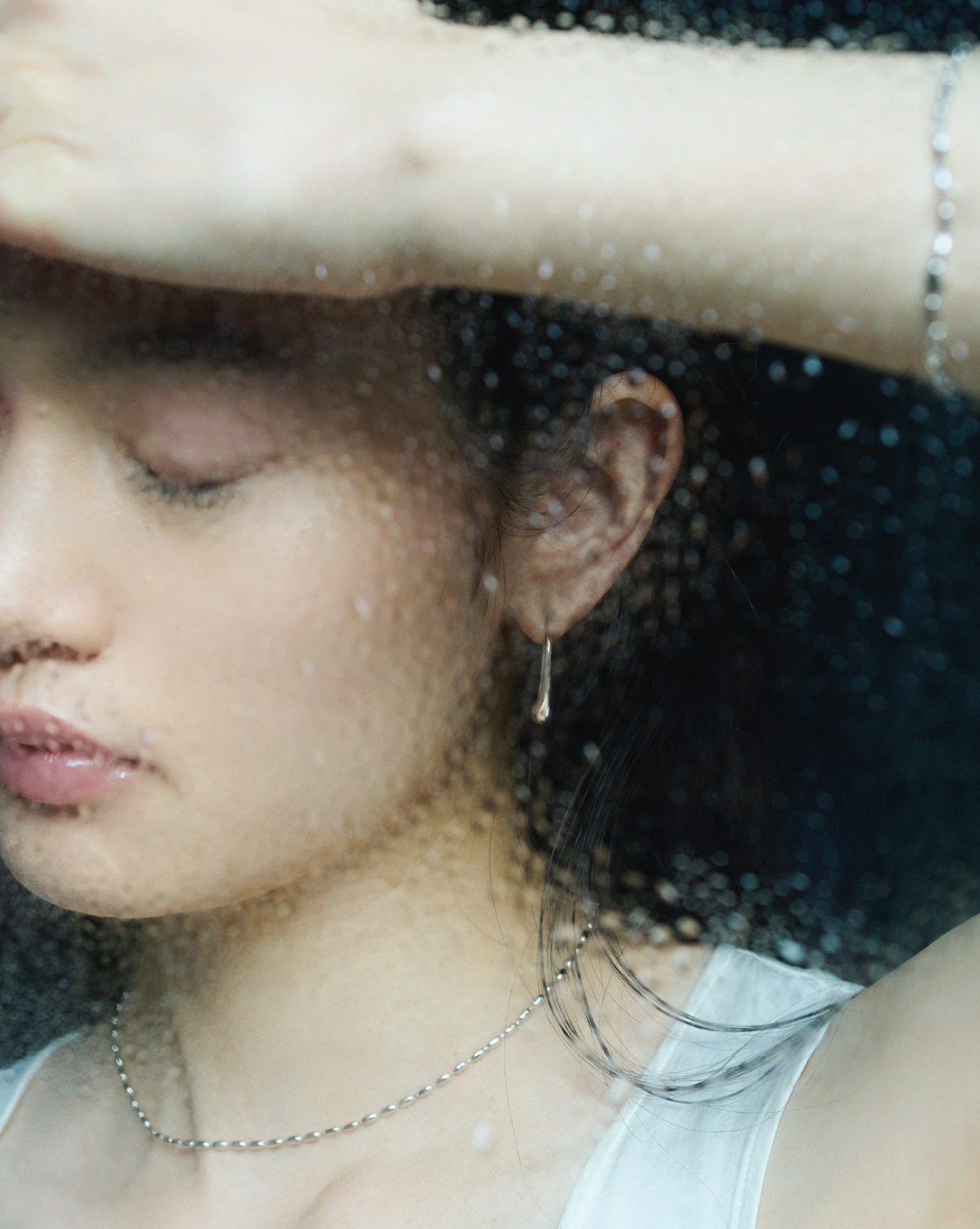 メタル素材の繊細なアクセを複数つけた女性